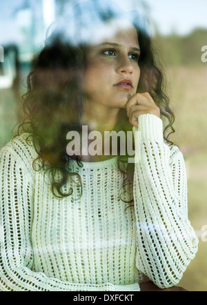 Close-up portrait of teenage girl looking out window, Germany Stock Photo