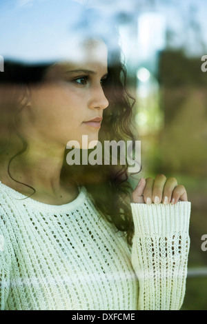 Close-up portrait of teenage girl looking out window, Germany Stock Photo