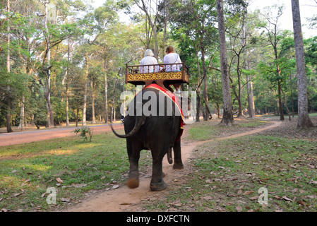 Two women tourists taking an elephant ride  around the ruined temples of Cambodia’s famed Angkor Wat, Siem Reap, Cambodia Stock Photo