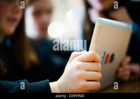 Primary school girls children using apple iPad tablet computers in class, Wales UK Stock Photo