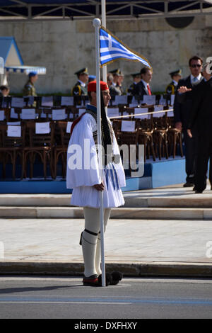 Athens, Greece March 25th- A Greek Evzonos or Tsolias (Presidential Guardsman) is standing as honour gurad while holding a Greek flag during the military parade to celebrate the 25th of March Greek Independece Day (Photo by George Panagakis/Pacific Press/Alamy Live News) Stock Photo
