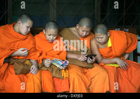 Young Monks sitting together on a bench Stock Photo