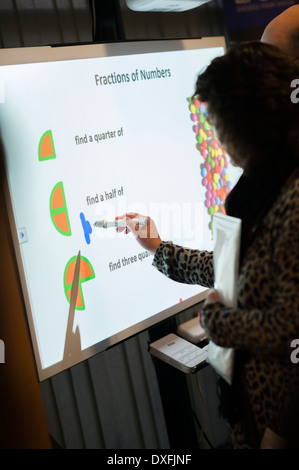 A woman teacher using an interactive touch sensitive digital white board in a mathematics class Wales UK Stock Photo