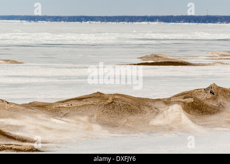 Frozen Lake Huron with sand and snow mixed drifts on the lake. Stock Photo