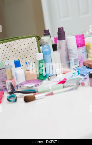 Women's toiletries and cosmetic travel bag on bathroom counter, with toothbrush, lotion, makeup and other beauty products, USA Stock Photo
