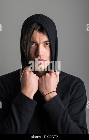 Portrait of handsome Malaysian man wearing hoodie and looking serious Stock Photo