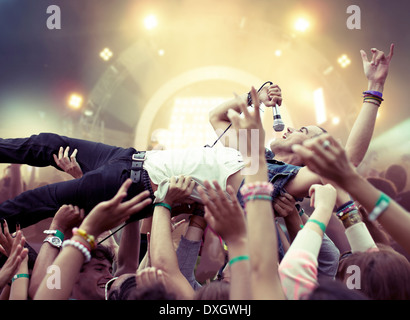 Performer crowd surfing at music festival Stock Photo
