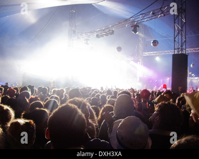 Fans facing illuminated stage at music festival Stock Photo