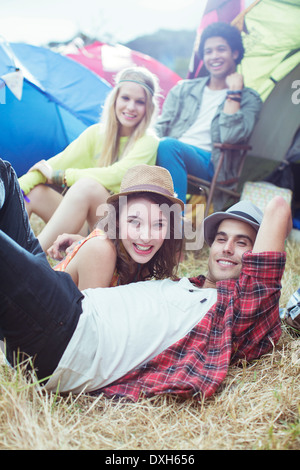 Portrait of friends hanging out outside of tents at music festival Stock Photo