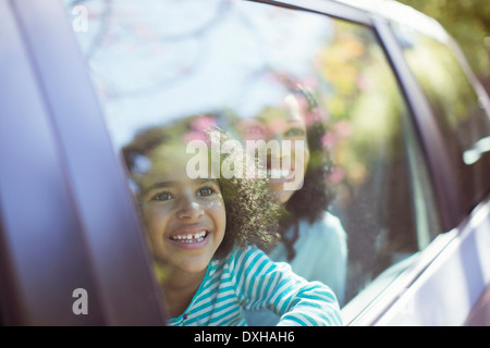 Happy mother and daughter looking out car window Stock Photo