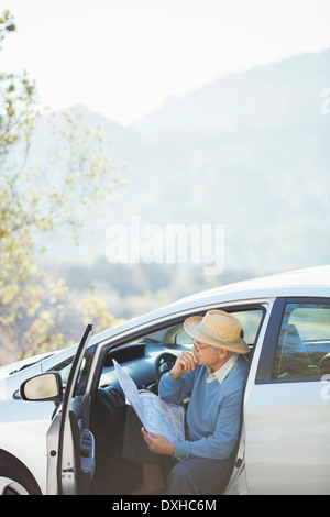 Senior man checking map in car Stock Photo