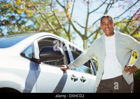 Portrait of confident senior man leaning against car Stock Photo