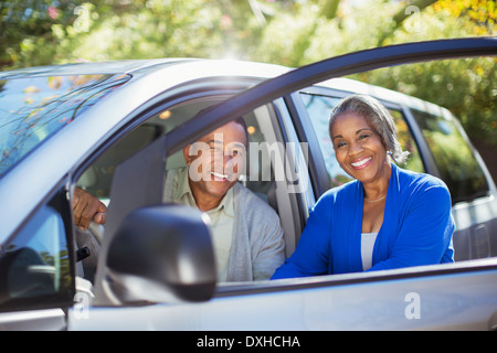 Portrait of happy couple inside and outside of car Stock Photo