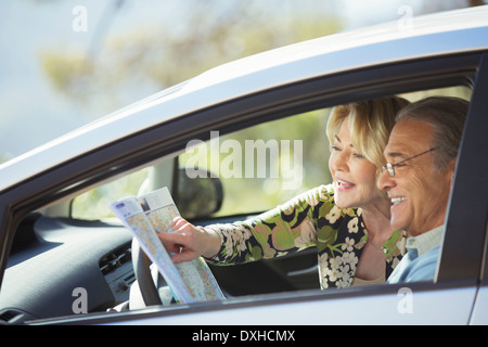 Senior couple looking at map inside car Stock Photo