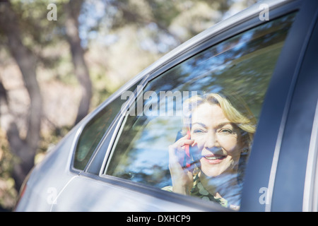 Senior woman talking on cell phone in car Stock Photo