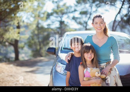 Portrait of happy family leaning on car Stock Photo