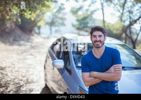 Portrait of smiling man leaning on car Stock Photo