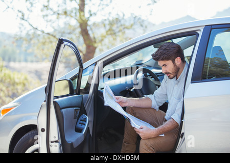 Man in car looking at map Stock Photo