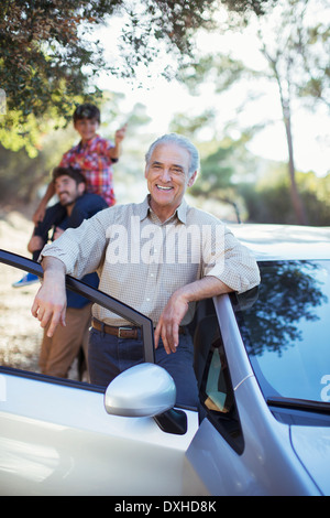 Portrait of confident senior man leaning against car Stock Photo