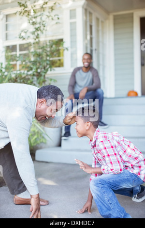 Grandfather and grandson practicing football stance Stock Photo