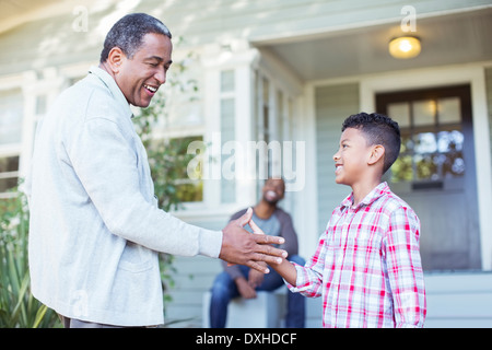 Grandfather and grandson exchanging special handshake outdoors Stock Photo
