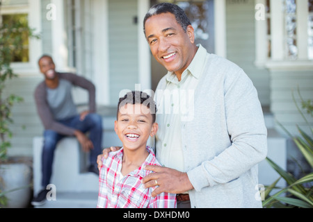 Portrait of smiling grandfather and grandson outside house Stock Photo