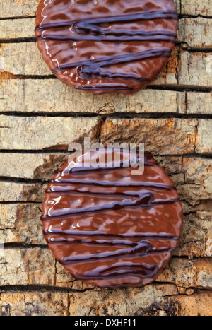 Decorated chocolate biscuits on wooden background. Stock Photo