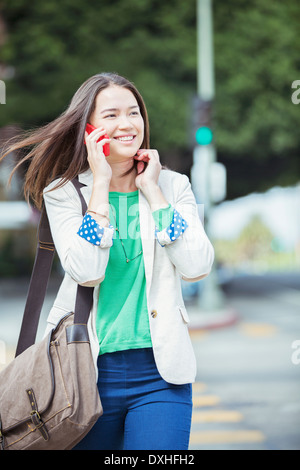 Happy businesswoman talking on cell phone in crosswalk Stock Photo