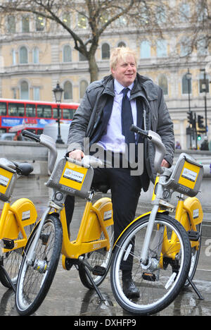 Trafalgar Square, London, UK. 26th March 2014. London Mayor Boris Johnson on one of the 100 special yellow bikes being placed around London to mark 100 days to the start of the Tour de France. Credit:  Matthew Chattle/Alamy Live News Stock Photo