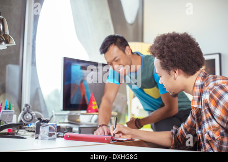 Casual businessmen reviewing paperwork in office Stock Photo