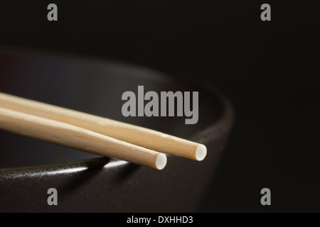 Two chopsticks on a black bowl Stock Photo