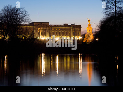 Buckingham Palace and Victoria Memorial reflected in lake in St James's Park at night twilight dusk London England UK Stock Photo