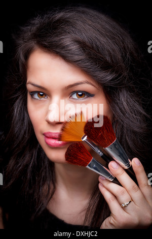 Beauty girl with makeup brushes Stock Photo