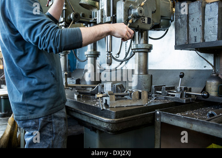 Caucasian man using drilling machine in workshop Stock Photo