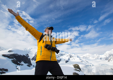 A passenger from an Antarctic cruise ship amongst stunning coastal scenery beneath Mount Walker in Paradise Bay Stock Photo