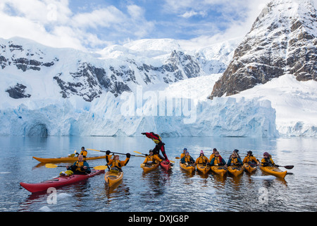Members of an expedition cruise to Antarctica sea kayaking in Paradise Bay beneath Mount Walker on the Antarctic Peninsular. Stock Photo