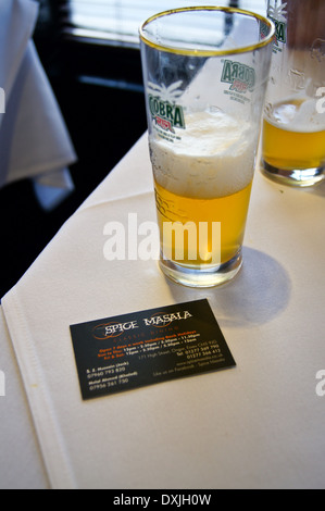 A glass of Cobra beer and business card Spice Masala indian restaurant, formerly Kismet Tandoori, Chipping Ongar, Essex, England pub table drinks glas Stock Photo