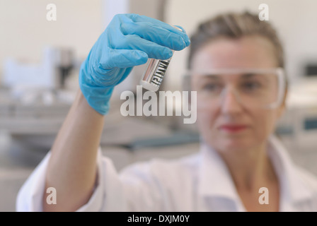 Lab technician looking at sample bottle in laboratory focus on hand Stock Photo