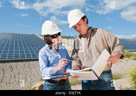 engineers looking at plans in solar plant Stock Photo