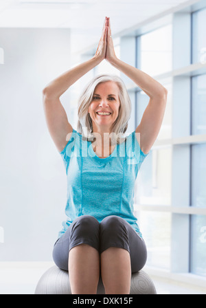 Portrait of happy Caucasian woman balancing on fitness ball Stock Photo