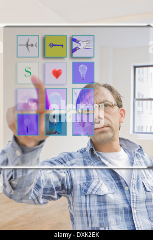 Hispanic man using mobile apps on virtual screen Stock Photo