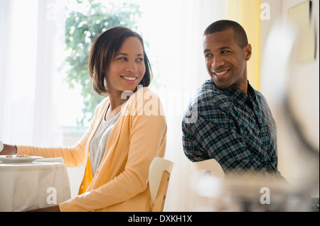 Man and woman turning to smile at each other in restaurant
