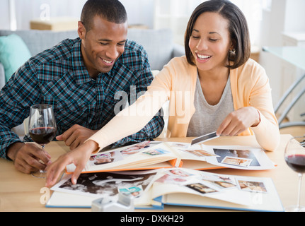 Couple drinking red wine and looking at photographs Stock Photo