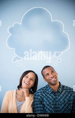Shared thought bubble above pensive couple Stock Photo