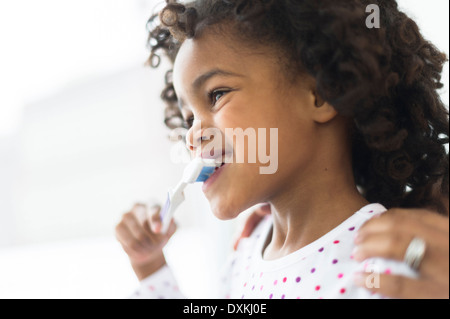 Close up of African American girl brushing teeth Stock Photo