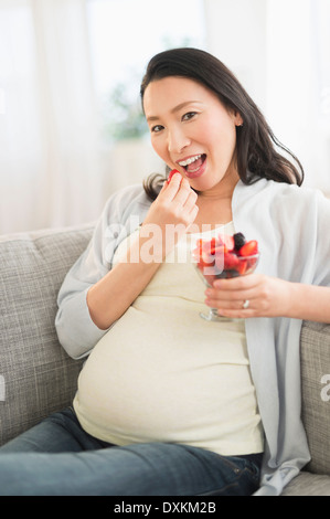Portrait of pregnant Japanese woman eating berries Stock Photo