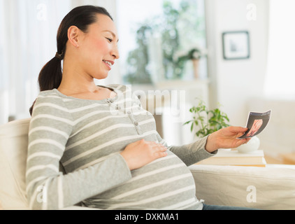 Pregnant Japanese woman looking at ultrasound image Stock Photo