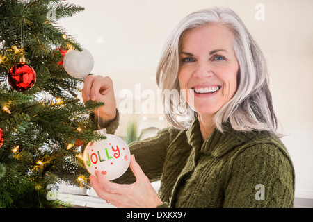 Portrait of Caucasian woman hanging ornaments on Christmas tree