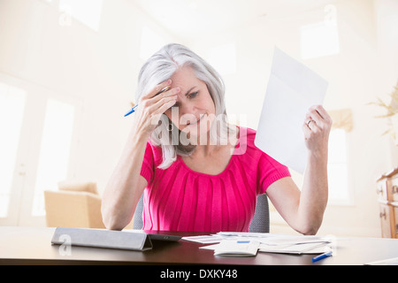 Frustrated Caucasian woman paying bills online