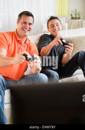 Caucasian father and son playing video games in living room Stock Photo